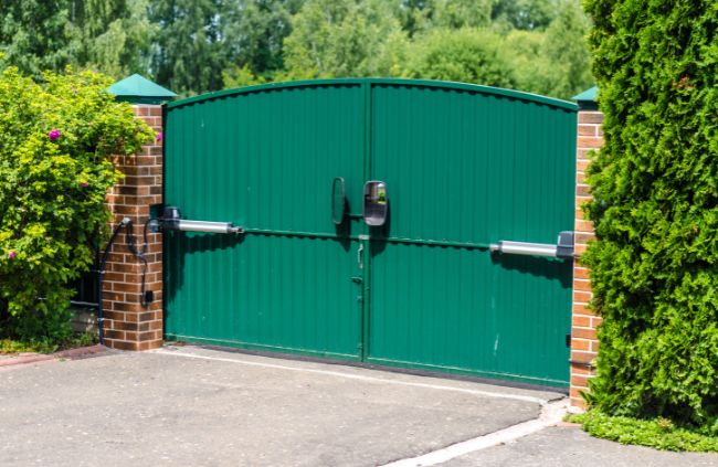 Motorised swing gate system installed by Auto Gate Guys Gold Coast, featuring green double gates and brick pillars for a secure driveway entrance Motorised swing gate system installed by Auto Gate Guys Gold Coast, featuring green double gates and brick pillars for a secure driveway entrance